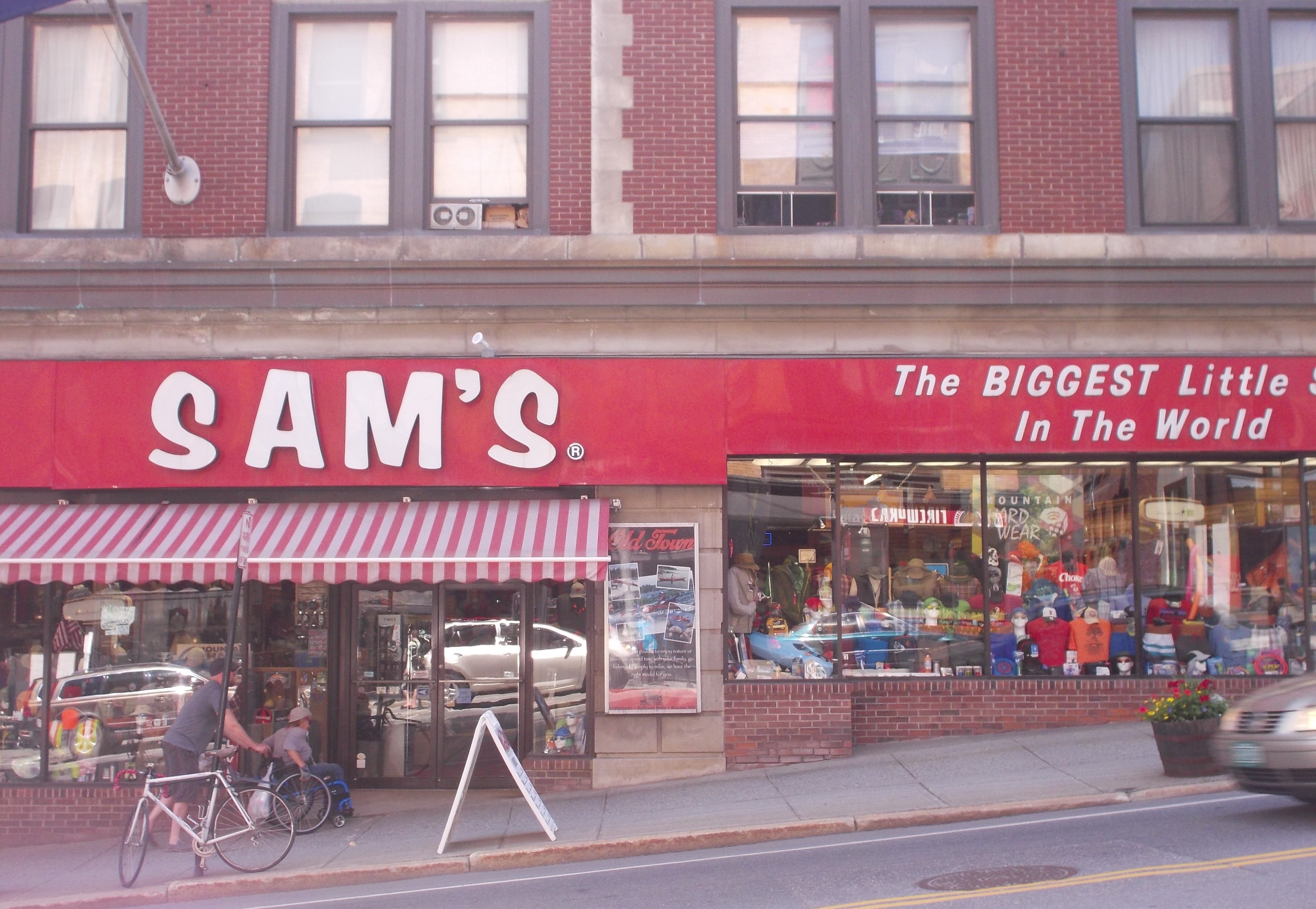 Sams Biggest Little signs, bike and man helping friend. photo Jen Austin